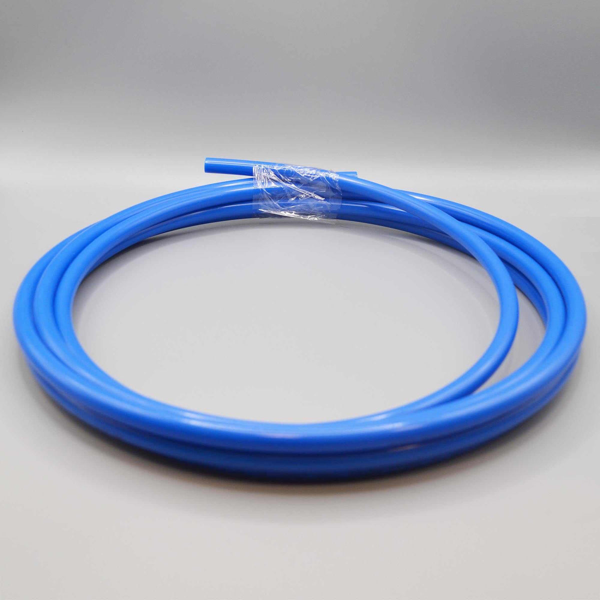 Blue flexible plastic tubing, SPECTRUM 3 with a smooth solid colour and a coiled shape secured with clear wrapping.